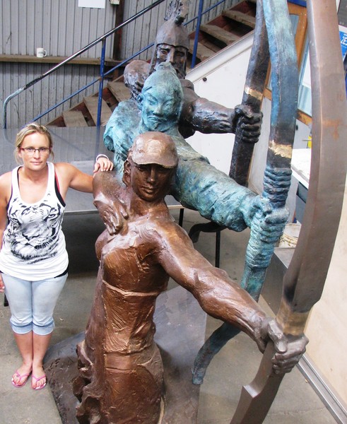 Tamara Toon from Gisborne Engineering is dwarfed by 'Evolution' the sculpture gifted to Gisborne City